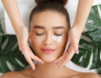 woman with eye masks receiving relaxing spa treatment