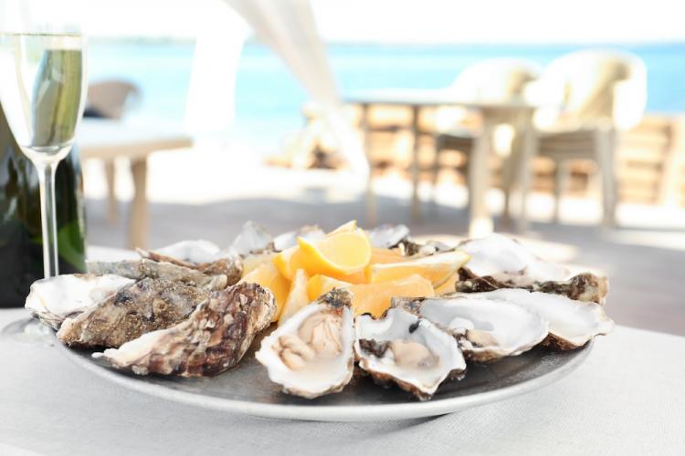 Fresh oysters with cut juicy lemon served on table.