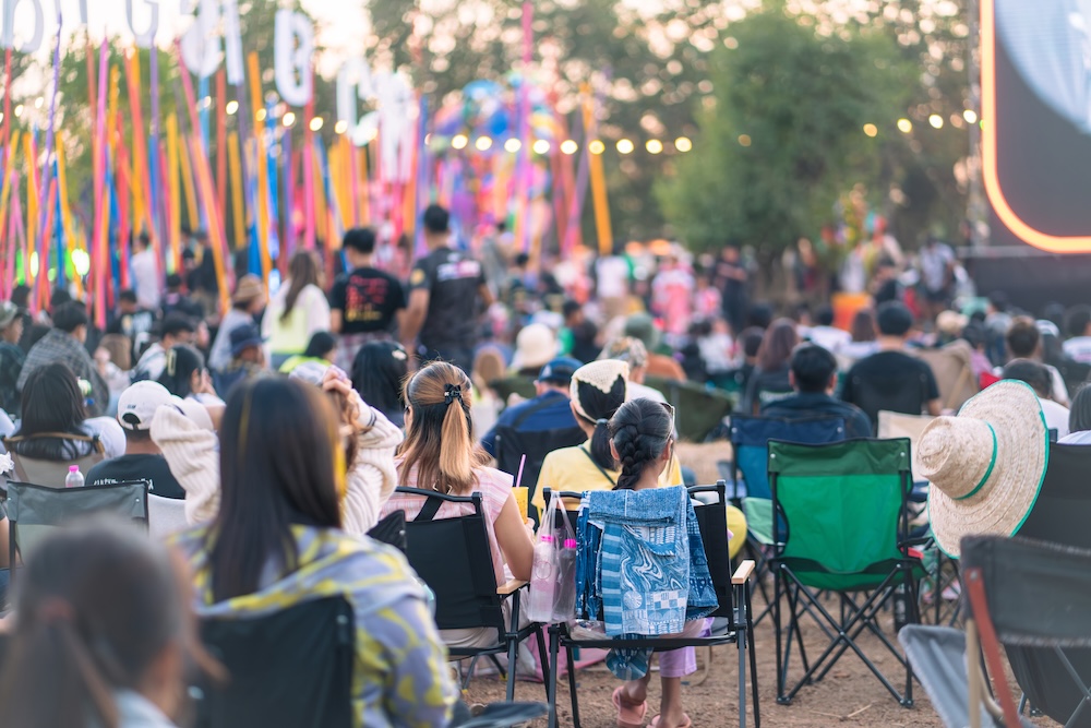 Crowd of people sitting in chairs.