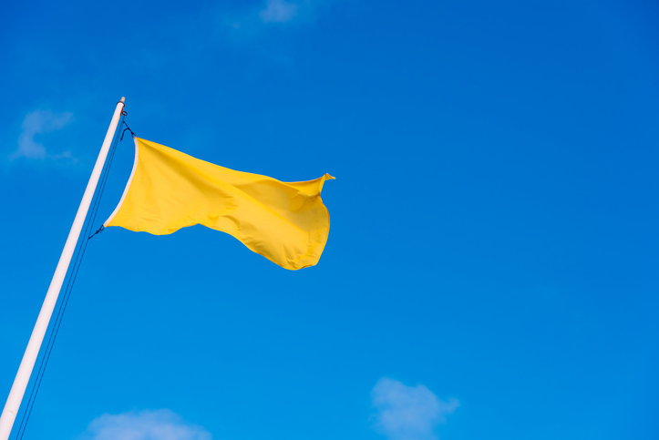 A yellow flag flies over the beach