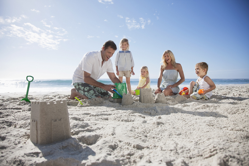 A family building a sandcastle in the sand